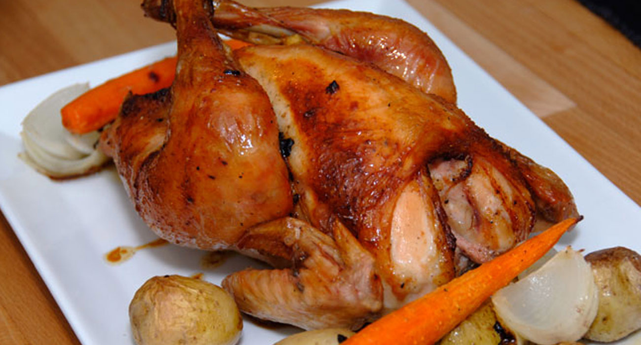 Whole roasted chicken on a bed of root vegetables — Mondo Dinner